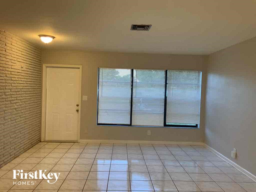 A room with a white door and a window with blinds.