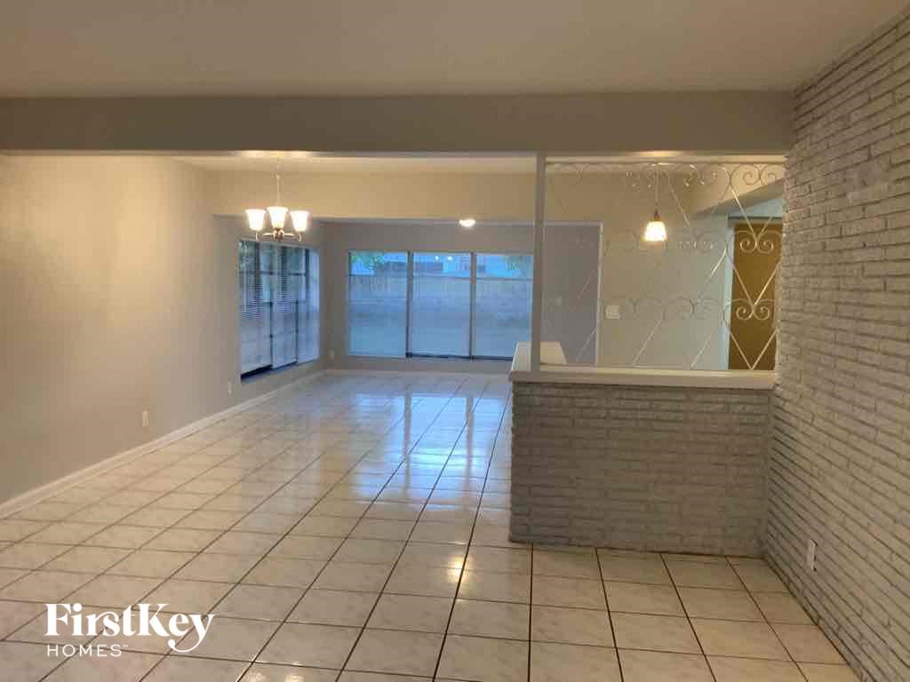 A spacious room with a brick wall and a tiled floor.