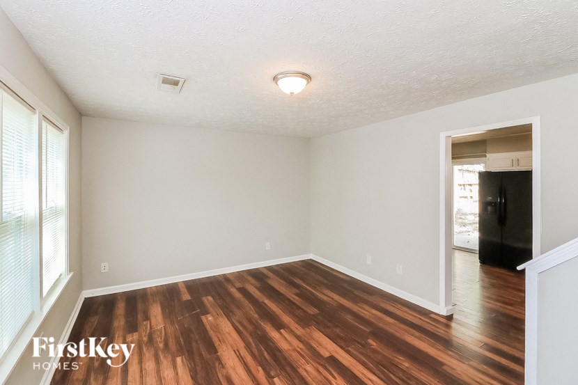 an empty living room with wood flooring and white walls