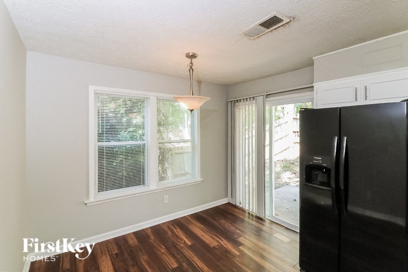 a kitchen with a black refrigerator and a sliding glass door