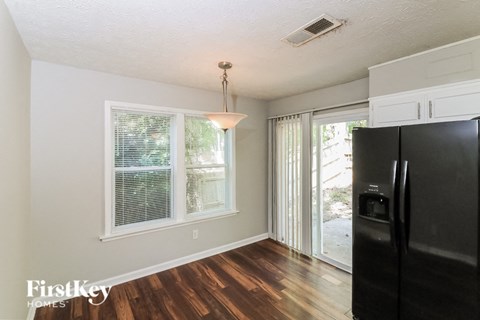 a kitchen with a black refrigerator and a sliding glass door