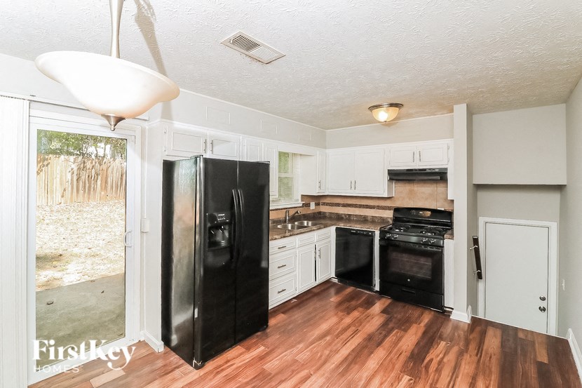a kitchen with a black refrigerator and a stove