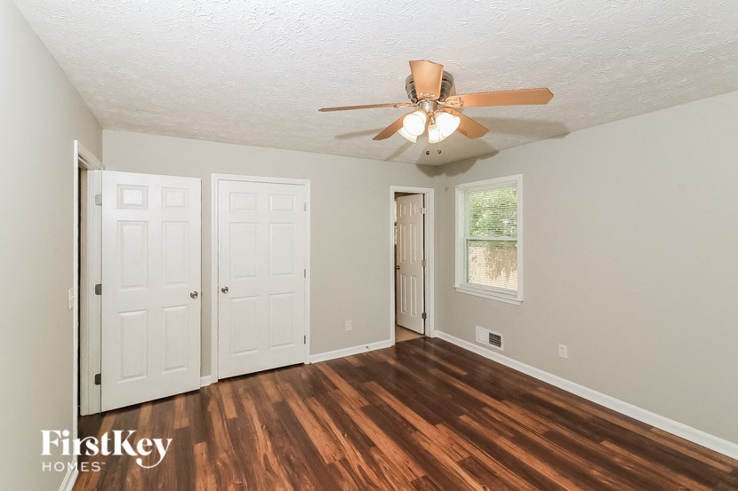 the living room of an empty house with a ceiling fan