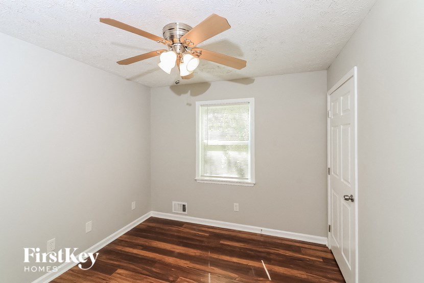 a bedroom with a ceiling fan and wood floors