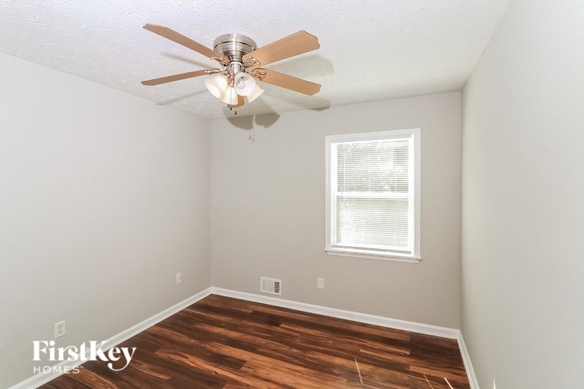 the living room of a home with a ceiling fan and wood floors