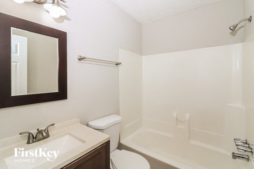 a bathroom with a sink toilet and a mirror