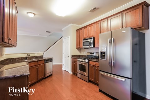 A kitchen with wooden cabinets and a stainless steel refrigerator.