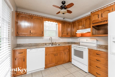A kitchen with wooden cabinets and white appliances.