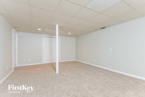 A spacious room with a carpeted floor and white walls.