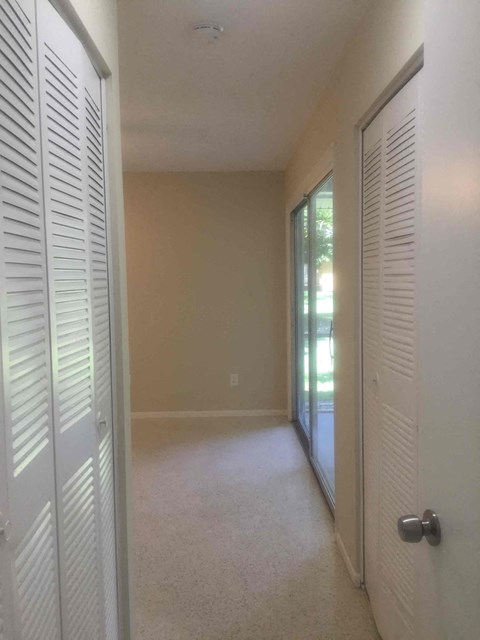a bedroom with a closet and a door to a patio