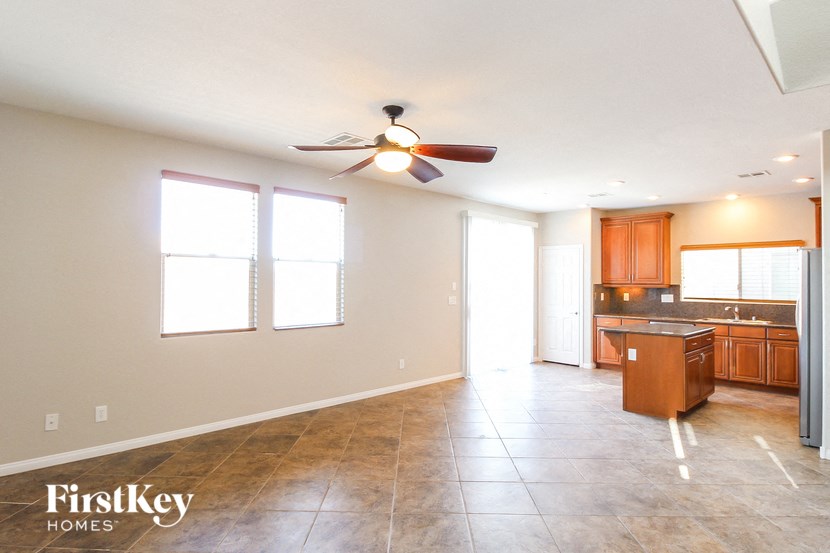 A spacious room with a ceiling fan and tiled floor.