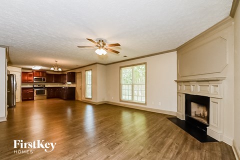 an empty living room with a fireplace and wooden floors