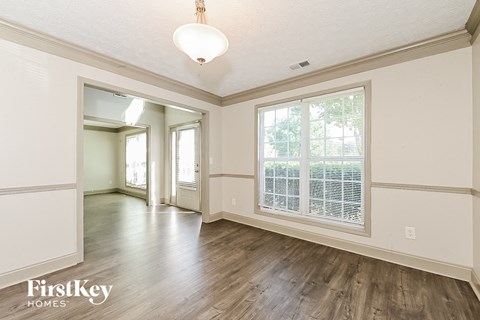 a living room and dining room with wood floors and a large window