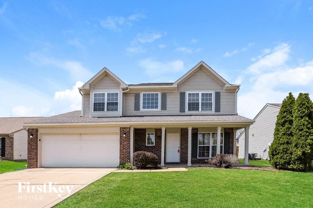 A two-story house with a garage is for sale.