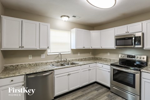A kitchen with white cabinets and stainless steel appliances.