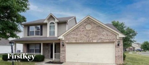 A brick house with a garage door is for sale.