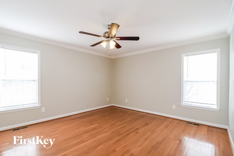 a living room with wood floors and a ceiling fan