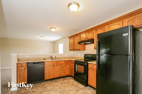 A kitchen with wooden cabinets and black appliances.