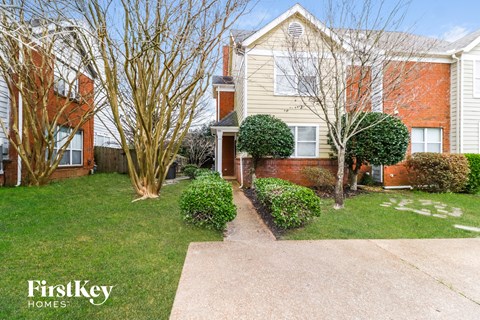A FirstKey Homes residential area with a building and a tree.
