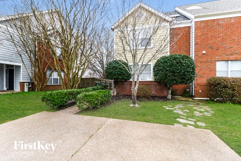 A brick house with a tree in front of it.