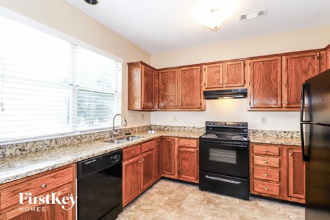 A kitchen with wooden cabinets and black appliances.