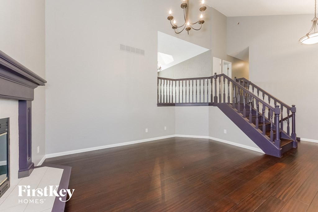 a living room with a fireplace and a staircase in a house