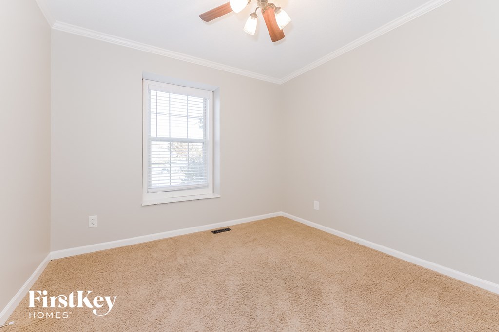 a bedroom with a ceiling fan and a window