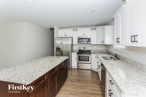 A kitchen with a granite countertop and stainless steel appliances.