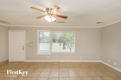 the living room has a ceiling fan and a tiled floor