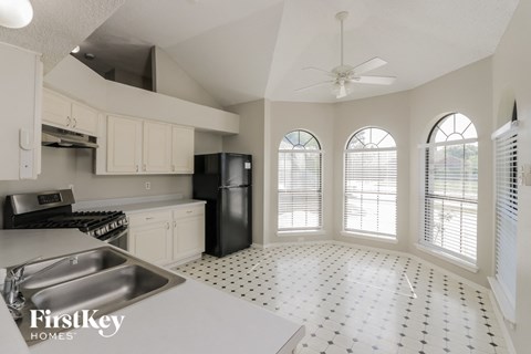 A kitchen with a sink, stove, and refrigerator.