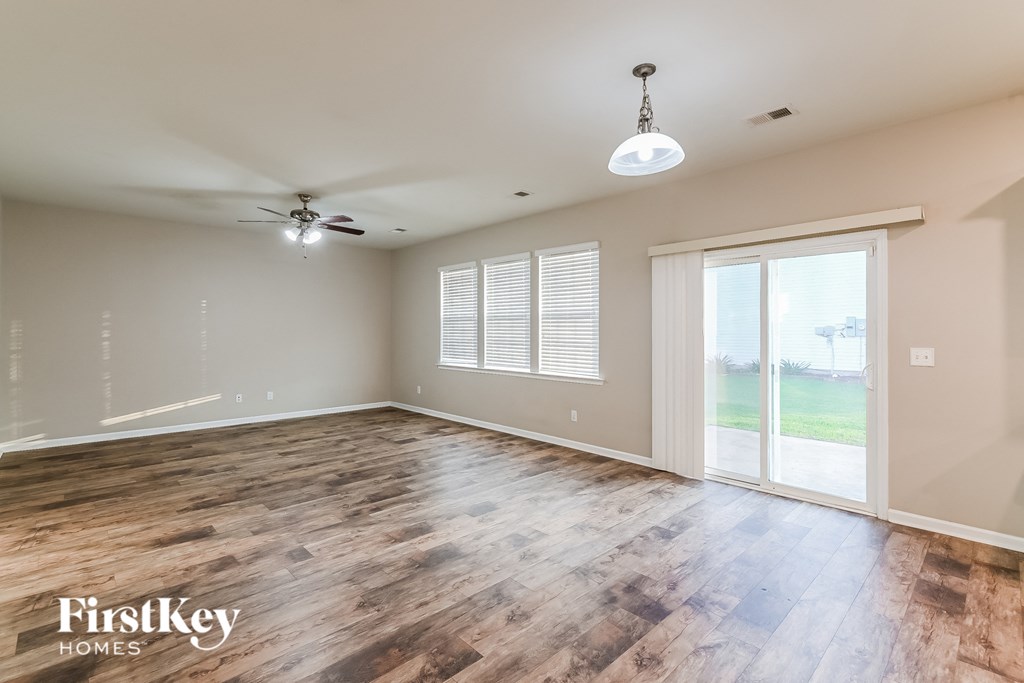 an empty living room with wood floors and a sliding glass door