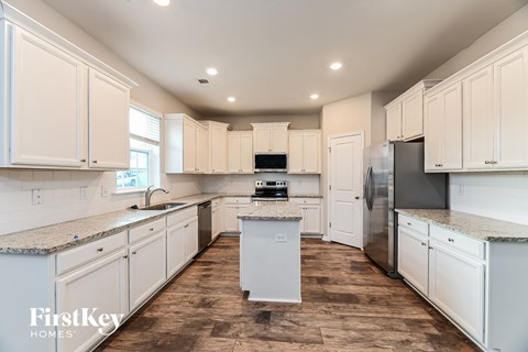 a white kitchen with white cabinets and stainless steel appliances