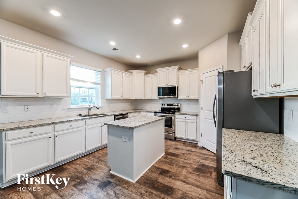 a white kitchen with white cabinets and marble counter tops