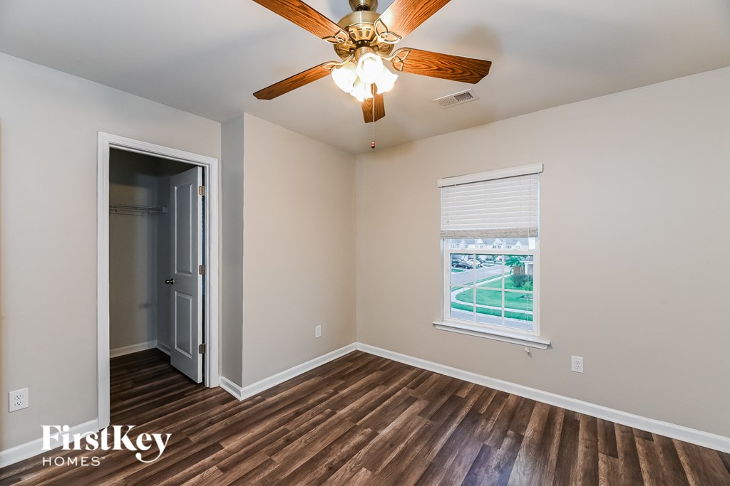 the living room has a ceiling fan and a door to the street