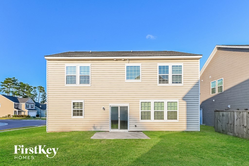 a yellow house with a green lawn and a blue sky