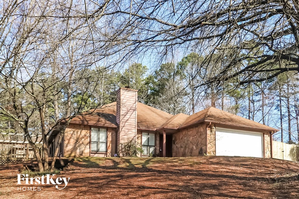 a house with a garage on a hill with trees