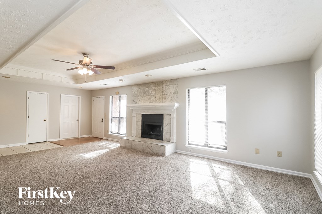 a living room with a fireplace and a ceiling fan