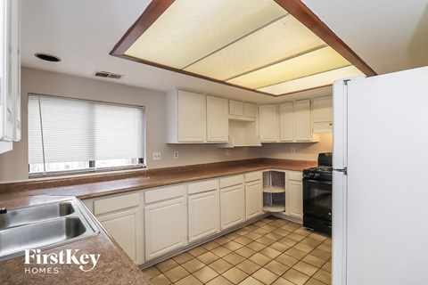 a kitchen with white cabinets and a counter top and a sink