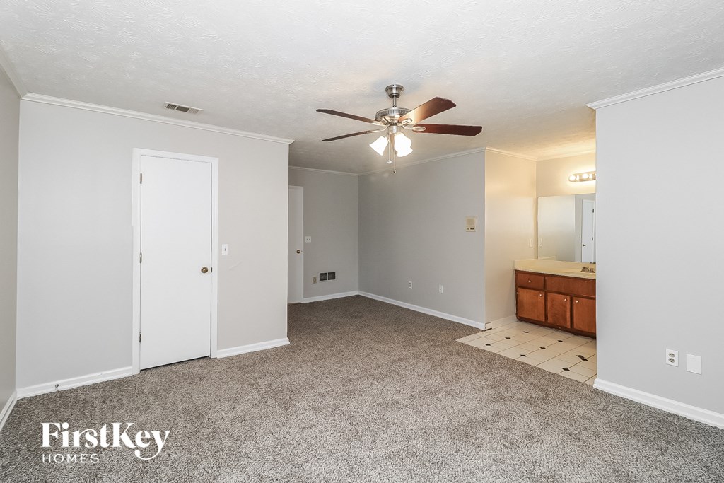 a bedroom with a ceiling fan and a bathroom