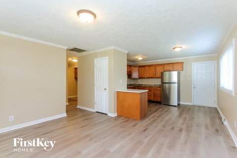 A kitchen with wooden floors and a refrigerator.