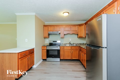 A kitchen with wooden cabinets and a stainless steel refrigerator.