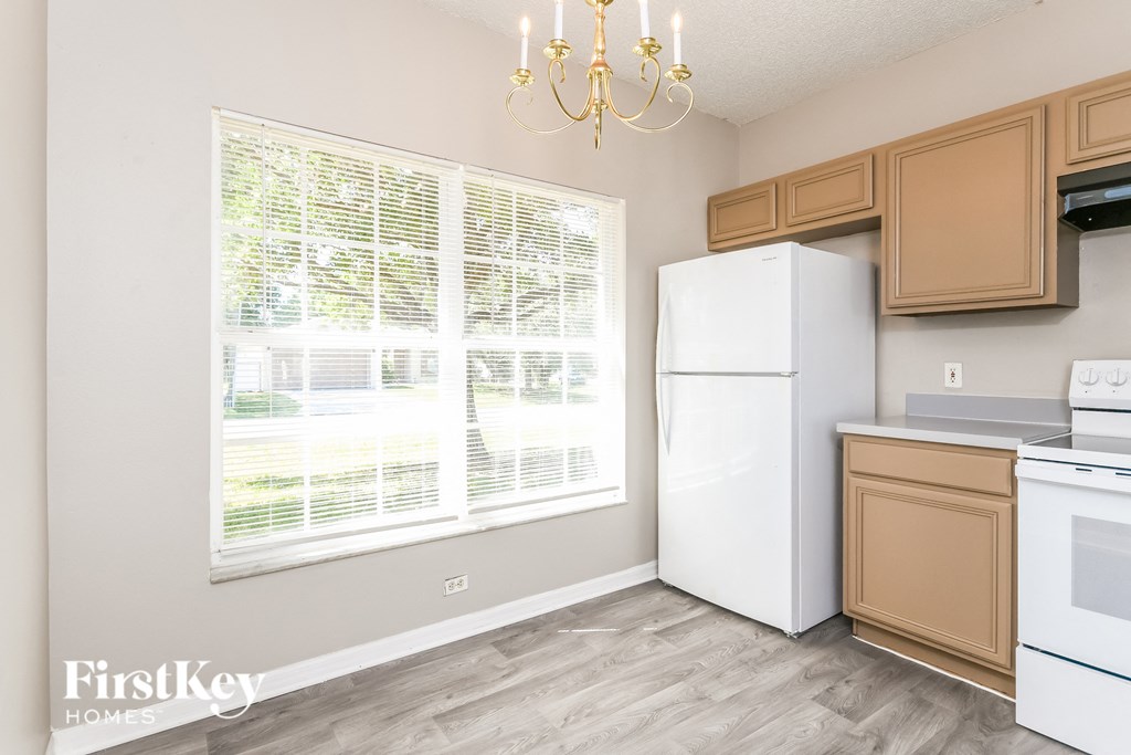 a kitchen with a large window and a white refrigerator