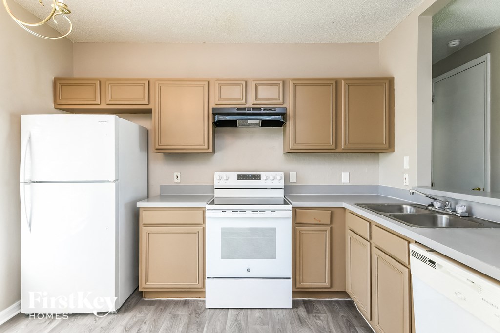 a kitchen with white appliances and wooden cabinets