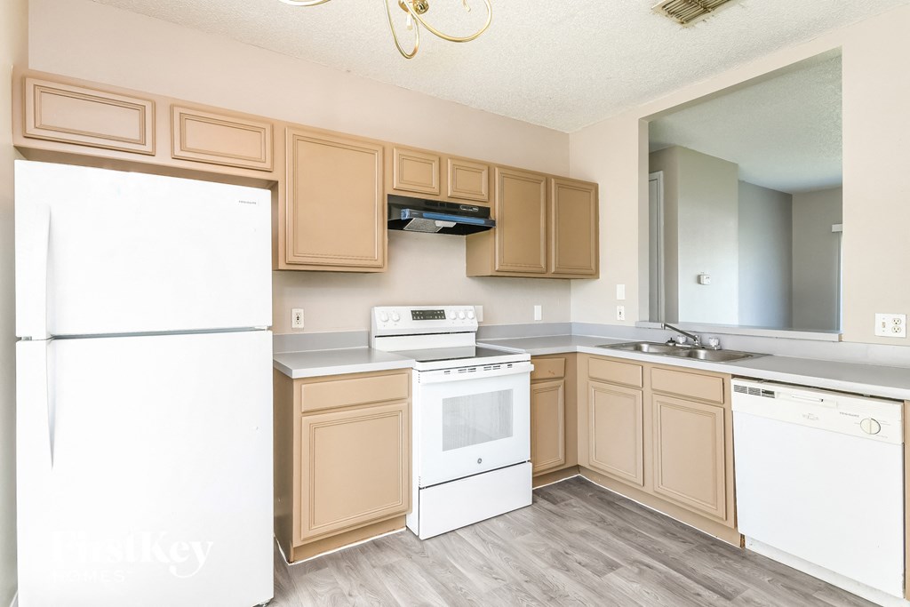 a kitchen with white appliances and wooden cabinets