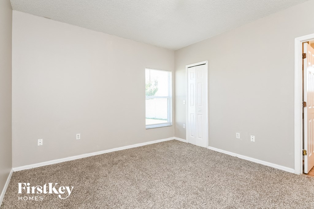 a bedroom with carpet and a door to a window
