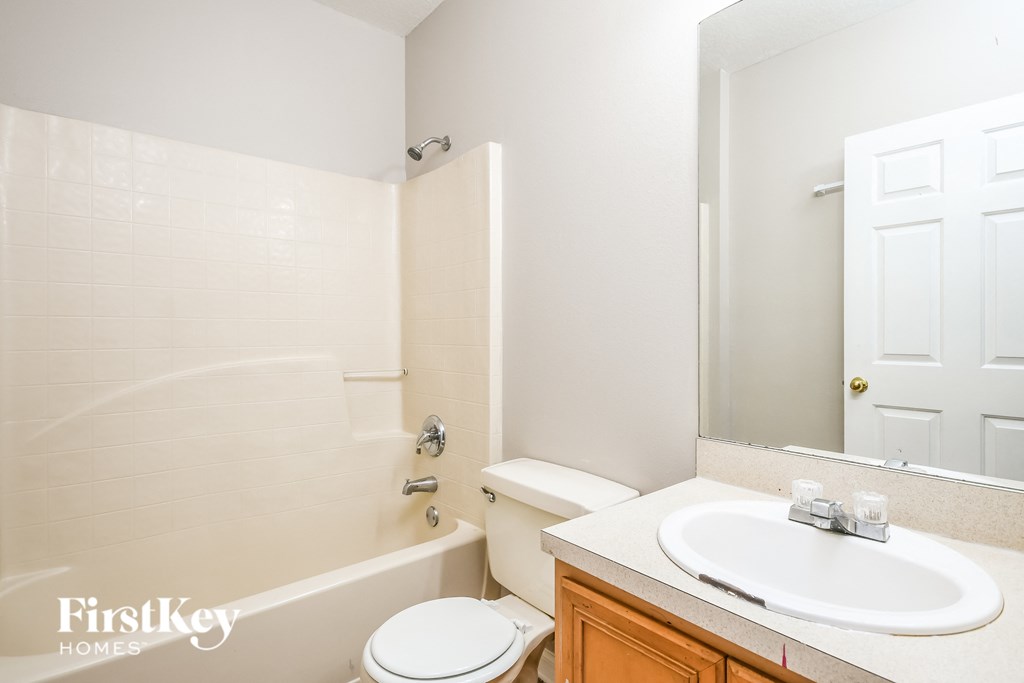 a bathroom with a sink toilet and tub and a mirror