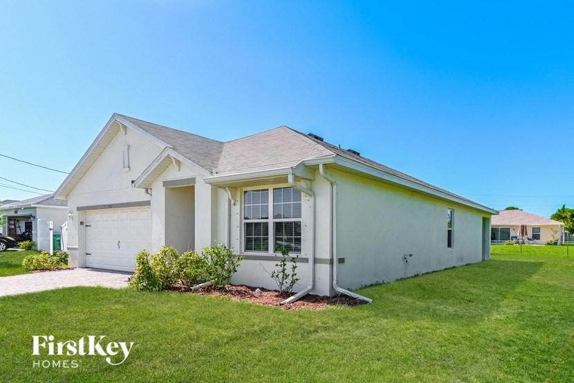 a white house with a lawn and a driveway