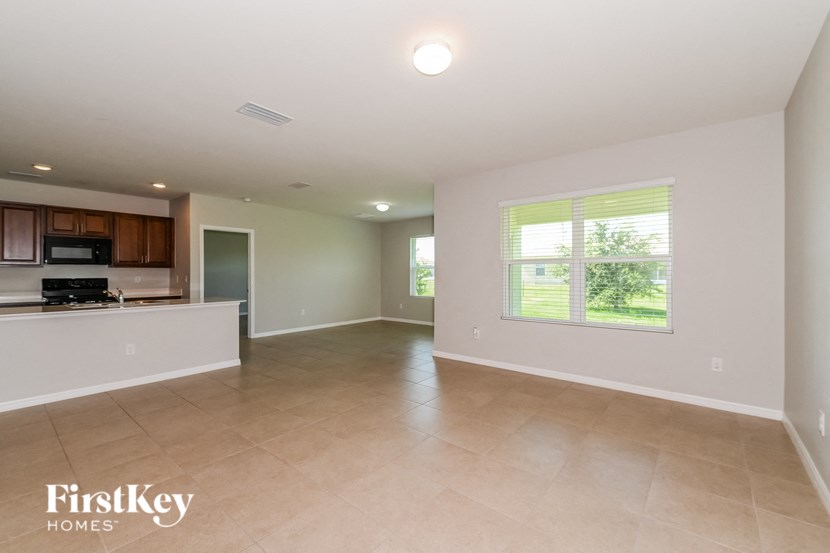 an empty living room and kitchen with a large window