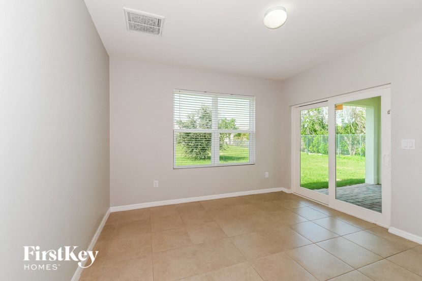a spacious living room with a large window and a door to the yard