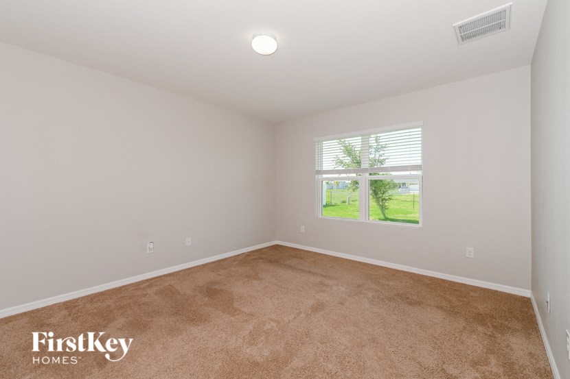 an empty room with a window and carpet